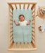 Baby wearing an ergoPouch Cocoon Swaddle Bag 1.0 TOG Oatmeal Marle