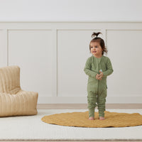 Toddler wearing an ergoPouch Long Sleeve Layer 1.0 TOG Moss