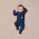 Baby wearing a navy blue, long sleeve layer from ergoPouch, made from organic, breathable materials.