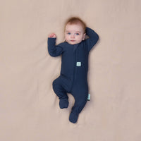 Baby wearing a navy blue, long sleeve layer from ergoPouch, made from organic, breathable materials.