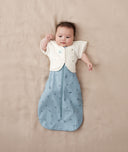 Baby wearing a blue ergoPouch cocoon swaddle paired with neutral colour butterfly cardi.