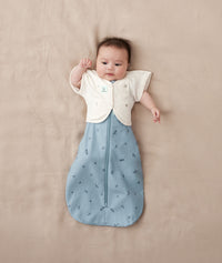 Baby wearing a blue ergoPouch cocoon swaddle paired with neutral colour butterfly cardi.