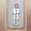 Baby lying in a cot wearing a Cocoon Swaddle Bag 2.5 TOG Clouds