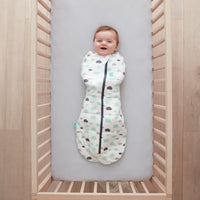 Baby lying in a cot wearing a Cocoon Swaddle Bag 2.5 TOG Clouds
