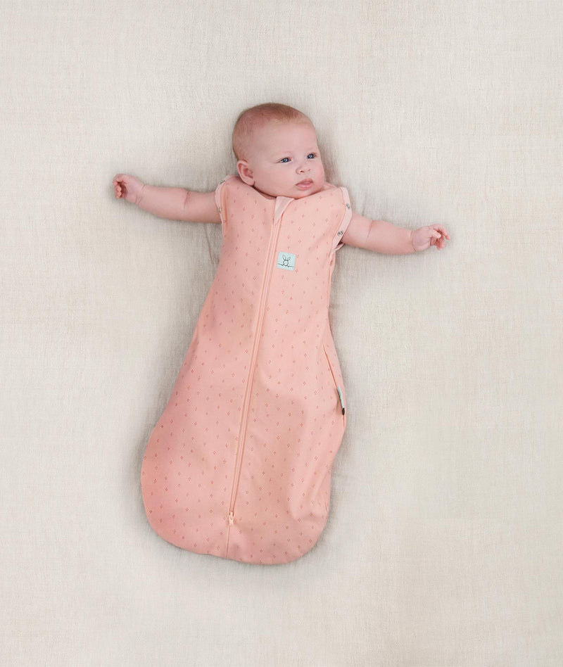 Baby wearing a lightweight ergoPouch Cocoon Swaddle Bag 0.2 TOG Berries with arms out