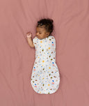 Newborn transitioning to arms-out sleeping, in an ergoPouch Cocoon Swaddle Bag 1.0 TOG Daydream