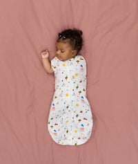 Newborn transitioning to arms-out sleeping, in an ergoPouch Cocoon Swaddle Bag 1.0 TOG Daydream