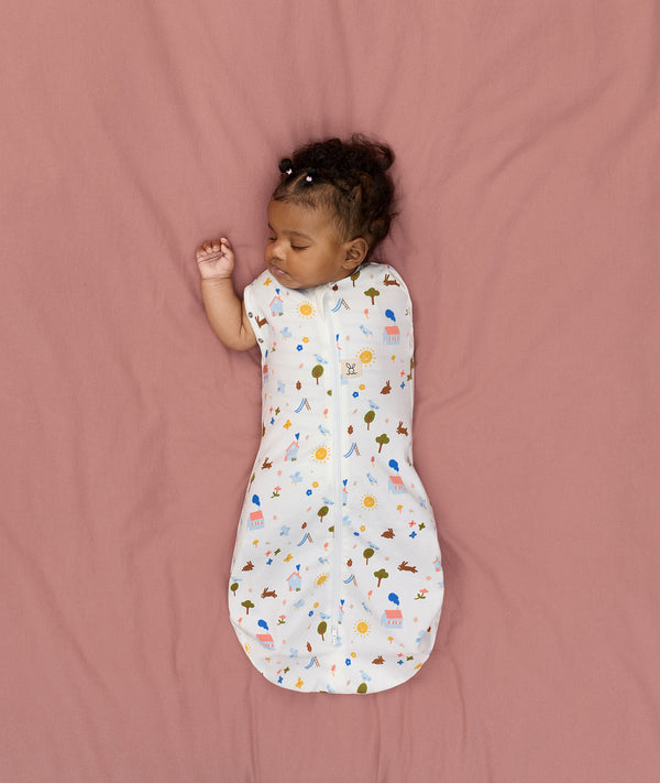 Newborn transitioning to arms-out sleeping, in an ergoPouch Cocoon Swaddle Bag 1.0 TOG Daydream