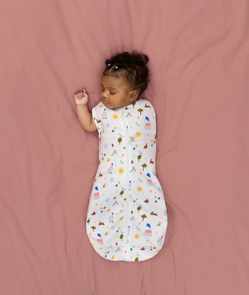 Newborn transitioning to arms-out sleeping, in an ergoPouch Cocoon Swaddle Bag 1.0 TOG Daydream