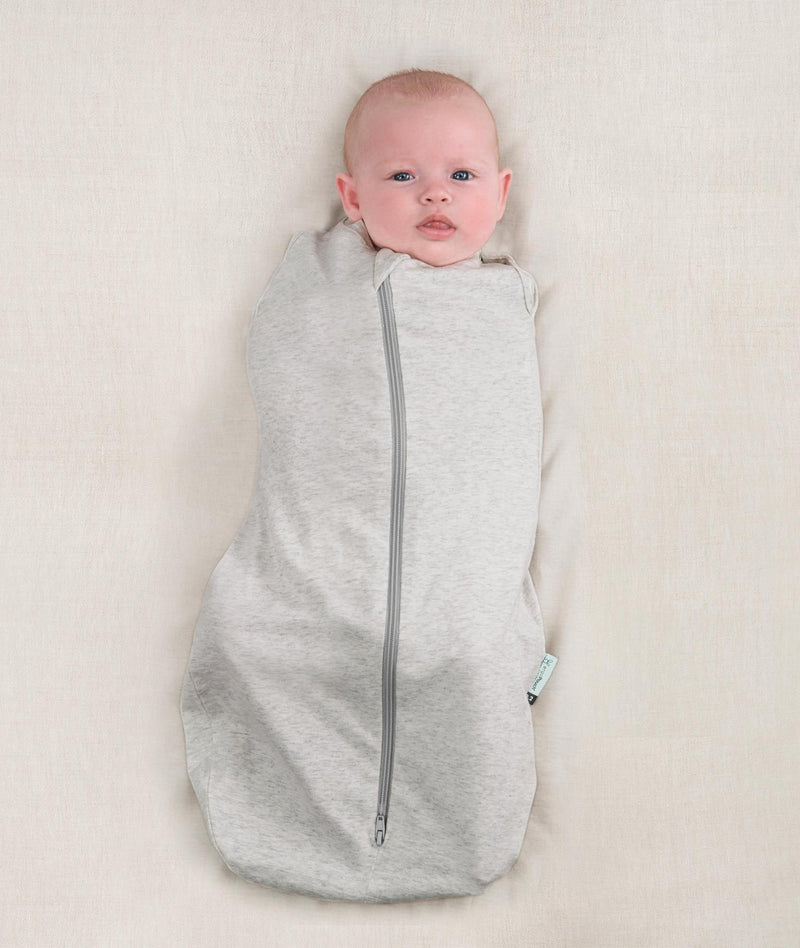 Newborn wearing an ergoPouch Cocoon Swaddle Bag 0.2 TOG Grey Marle with arms in