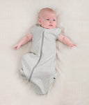 Newborn wearing an ergoPouch Cocoon Swaddle Bag 0.2 TOG Grey Marle with arms out