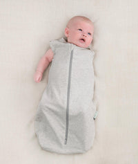 Newborn wearing an ergoPouch Cocoon Swaddle Bag 0.2 TOG Grey Marle with one arm out