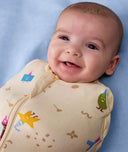 Baby smiling wearing an ergoPouch Cocoon Swaddle Bag 1.0 TOG Birthday Blobs