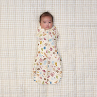 Baby being swaddled in ergoPouch Cocoon Swaddle Bag 1.0 TOG in Bon Appetit