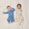 Baby swaddled in ergoPouch Cocoon Swaddle Bag 1.0 TOG in Bon Appetit with another baby lying beside in ergoPouch Long Sleeve Layer 1.0 TOG Petit Pretzel