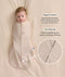 Baby wrapped in a Cocoon Swaddle Bag lying on a cream-coloured blanket with text highlighting 
