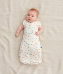 Baby wearing a Cocoon Swaddle Bag 1.0 TOG Desert Bloom,  transitioning into arms out sleeping