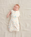 Baby wearing a Cocoon Swaddle Bag 1.0 TOG Desert Bloom, one arm out