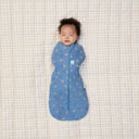 Newborn being swaddled in ergoPouch Cocoon Swaddle Bag 0.2 TOG in Petit Pretzel