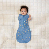 Newborn transitioning to arms out sleeping with one arm out in a ergoPouch Cocoon Swaddle Bag 0.2 TOG in Petit Pretzel