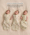 Three babies lying side by side demonstrating the conversion of a Cocoon Swaddle to a Sleeping Bag, progressing from both arms in, one arm out, to both arms out.