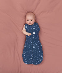 Baby transitioning to arms out sleeping easily with the ergoPouch Cocoon Swaddle Bag 1.0 TOG Starbeam