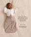 Infant wearing a Cocoon Swaddle Bag  layered with a cream 