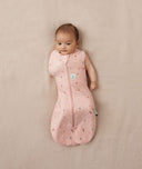 Baby wearing a lightweight ergoPouch Cocoon Swaddle Bag 0.2 TOG Daisies with one arm out