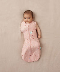 Baby wearing a lightweight ergoPouch Cocoon Swaddle Bag 0.2 TOG Daisies with one arm out