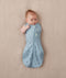 Newborn wearing an ergoPouch Cocoon Swaddle Bag 0.2 TOG Dragonflies with one arm out