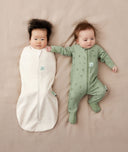 Two babies, one wearing a Cocoon Swaddle Bag 0.2 TOG Oatmeal Marle and the other in a Layer