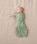 Newborn wearing an ergoPouch Cocoon Swaddle Bag 0.2 TOG Willow with one arm out