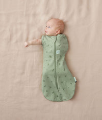 Newborn wearing an ergoPouch Cocoon Swaddle Bag 0.2 TOG Willow with one arm out