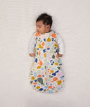 Newborn wearing an ergoPouch Cocoon Swaddle Bag 2.5 TOG Fruit Salad with arms out
