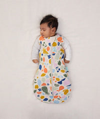 Newborn wearing an ergoPouch Cocoon Swaddle Bag 2.5 TOG Fruit Salad with arms out