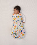 Newborn wearing an ergoPouch Cocoon Swaddle Bag 2.5 TOG Fruit Salad with one arm out