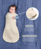 Product infographic showing a baby with one arm out in a Cocoon Swaddle Bag on a blue background, highlighting armhole press studs and a bell-shaped design.