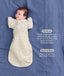 Product infographic showing a baby wearing a Cocoon Swaddle Bag paired with a Butterfly Cardi layer on a blue fabric background with text highlighting hands up sleeping and wash & wear friendly feature.
