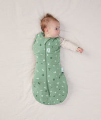 Newborn wearing an ergoPouch Cocoon Swaddle Bag 2.5 TOG Sweet Orchard with one arm out