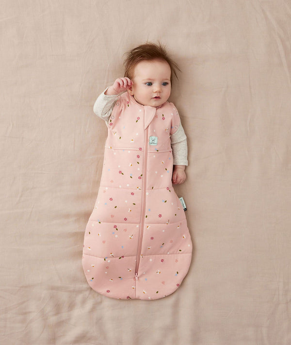 Newborn wearing an ergoPouch Cocoon Swaddle Bag 2.5 TOG Daisies with arms out