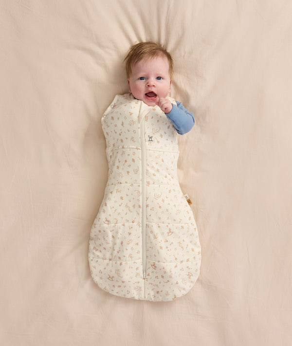 Baby wearing a Cocoon Swaddle Bag 2.5 TOG Lullaby with one arm out