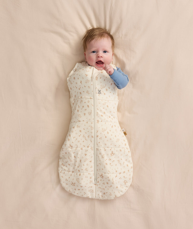 Baby wearing a Cocoon Swaddle Bag 2.5 TOG Lullaby with one arm out