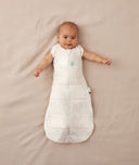 Newborn wearing an ergoPouch Cocoon Swaddle Bag 2.5 TOG Oatmeal Marle with arms out
