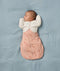 Baby is sleeping on a soft blue blanket, wearing a Butterfly Cardi over a Cocoon Swaddle Bag.
