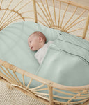 Baby tucked in an organic ergoPouch fitted sheet, made from premium, non-irritating materials gentle on baby's skin.