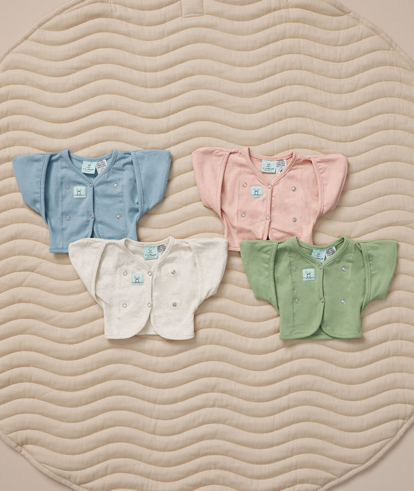 Flat lay of ergoPouch butterfly cardi in various colors, ideal for pairing with a cocoon swaddle.