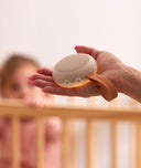 Mum holding an ergoPouch white noise machine to help soothe her baby to sleep.