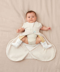Baby with hip dysplasia wearing ergoPouch Hip Harness Cocoon Swaddle Bag 0.2 TOG Oatmeal Marle