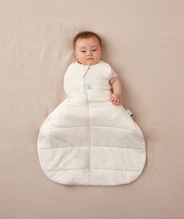 Newborn wearing an ergoPouch Hip Harness Cocoon Swaddle Bag 2.5 TOG Oatmeal Marle with one arm out