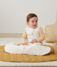 Newborn sitting, wearing an ergoPouch Hip Harness Jersey Sleeping Bag 3.5 TOG Oatmeal Marle